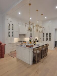 A kitchen with white cabinets and wooden floors