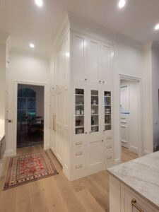 A kitchen with white cabinets and a rug.