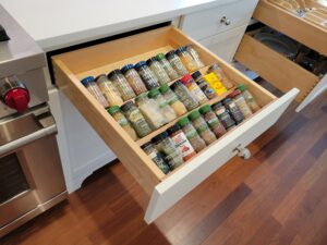 A drawer with spices in it is organized.