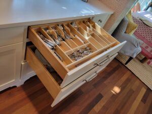 A drawer with many compartments and a knife holder.