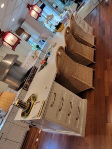 A kitchen with wooden floors and white cabinets.