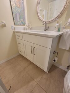 A bathroom with white cabinets and a sink.