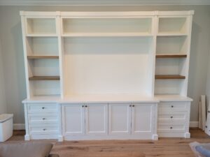 A white entertainment center with shelves and drawers.