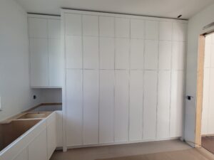 A large white cabinet in the middle of a room.