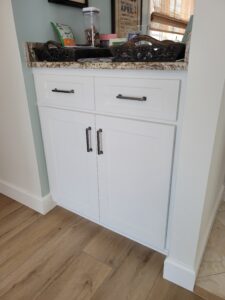 A white cabinet with two drawers and one door.