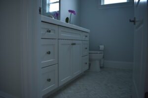 A bathroom with white cabinets and a toilet.