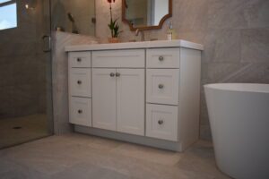 A bathroom with white cabinets and a sink.