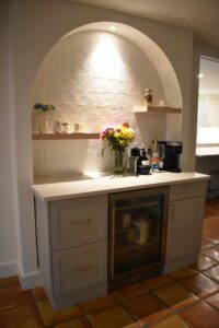 A kitchen with a sink, refrigerator and coffee maker.