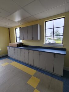A kitchen with yellow walls and black counter tops.