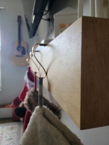 A coat rack with two coats hanging on it.