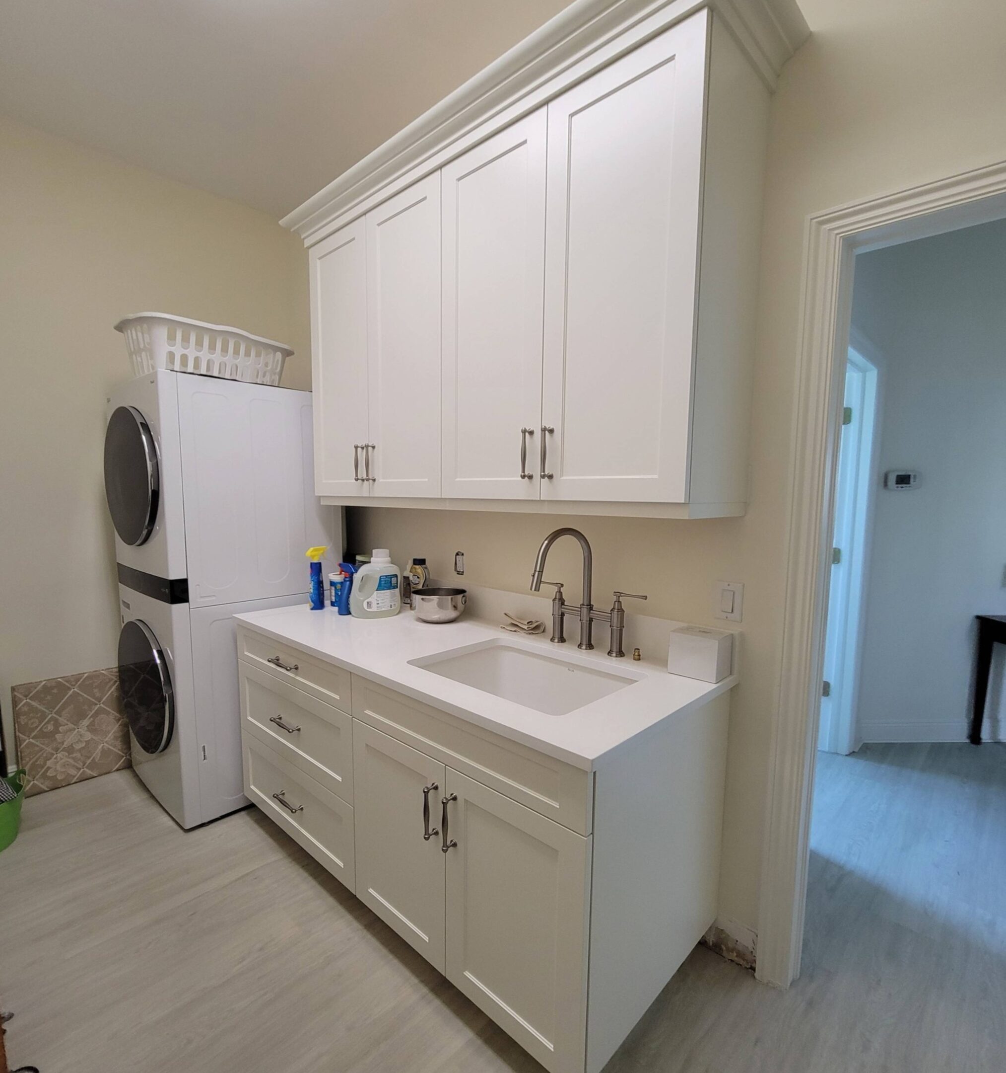 A kitchen with white cabinets and a washer dryer.