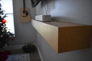 A white box sitting on top of a wooden shelf.